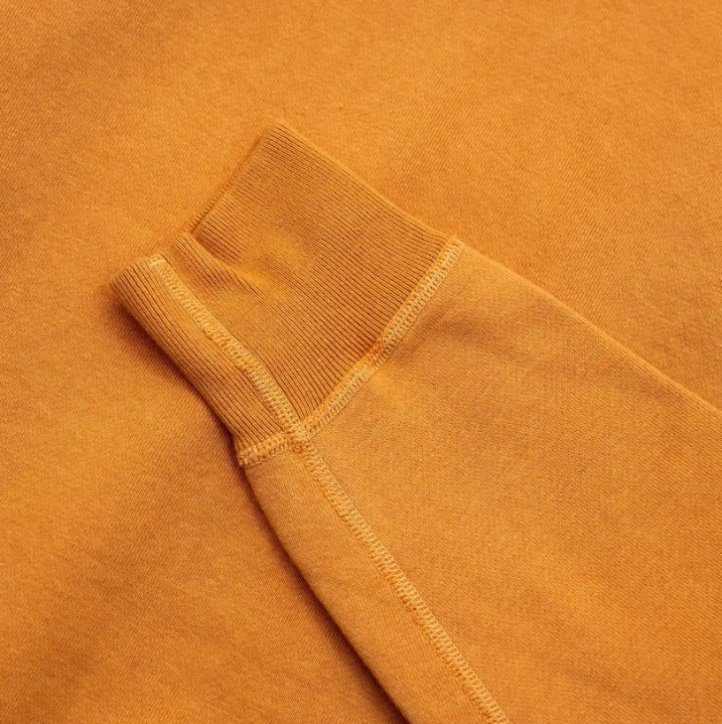 Close-up of Buzz Rickson's orange sweatshirt showcasing set-in sleeves and ribbed details.